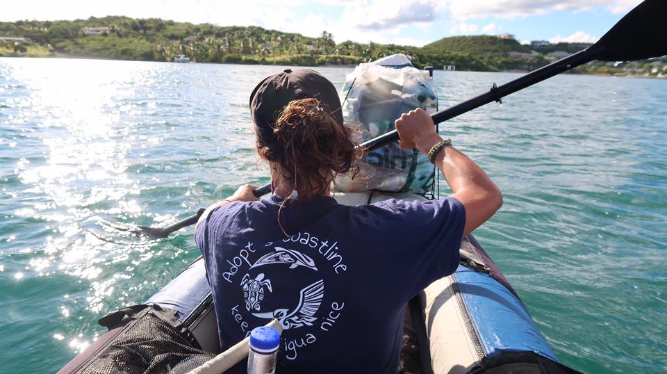 woman kayaking picking up rubbish